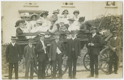  [Photographic postcard of an unidentified group of people and 4 wheeled wagon].