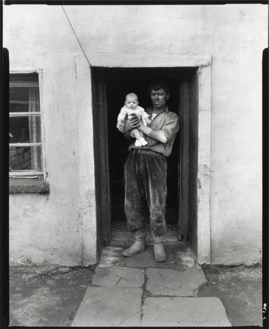 Coal Covered Miner Holding Baby in Doorway