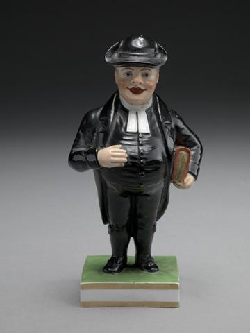 Derby porcelain factory A Cleric: rotund figure in white clerical collar and black robes, with a red book tucked under his arm