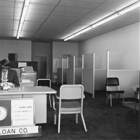 Robert Adams, Untitled (loan company cubicles with man in glasses), 1970–74