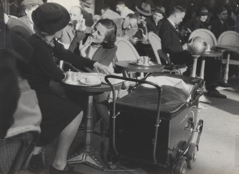 Lucien Aigner, Mother brings baby with her to the cafe. This is a frequent sight in Paris especially as a consequence of the French law prohibiting parents from leaving children unguarded in the house., 1930s